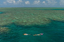 Snorkellers swimming the reefs of the Great Barrier Reef with a semi-submesible carrying tourists to see the reef from underwater, Great Barrier Reef, Queensland, Australia October 2016.