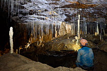 Speleothem (cave mineral deposit) with caver Bauges Massif UNESCO Geopark,  Savoy / Savoie, France, February.