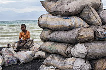 Child selling bags of charcoal bags north of Port-Au-Prince, Haiti.