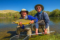 Man and woman  with prize 6lb male hook jawed Brown trout (Salmo trutta)  Beaverhead River, Montana, USA.