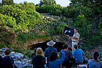 Visitors to Bracken Cave listening as Fran Hutchens, Bat Conservation International's director of Bracken Cave Preserve, gives educational information to visitors about the lives and existence of the...