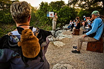 Visitors to Bracken Cave listening as Fran Hutchens, Bat Conservation International's director of Bracken Cave Preserve, gives educational information to visitors about the lives and existence of the...