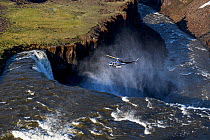 Helicopter over waterfall in Putoransky State Nature Reserve, Putorana Plateau, Siberia, Russia