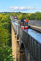 Canal barges crossing the Pont-Cysyllte aqueduct heading north over the River Dee near Trevor in the Vale of Llangollen North Wales UK September 2017