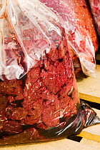 Seal meat in a bag on the quayside, Ilulissat, Greenland. The seal was shot by an Inuit hunter. July 2008.