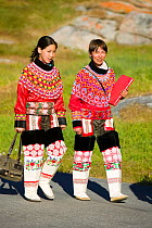 Inuit women wearing traditional Greenlandic national costume or Kalaallisuut, Ilulissat on Greenland. The costume consists of seal skin boots (Unnaat) bead necklaces (Nuilaqutit) and seal skin trouser...