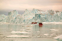 Tourist boat trips sail through Icebergs from the Jacobshavn glacier or Sermeq Kujalleq, Greenland, July 2008.