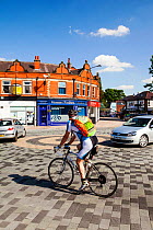 Cyclist in Poynton village, Cheshire which has recently undertaken a shared space road experiment, where pedestrians and vehicles share the same space. England, UK, May 2012.
