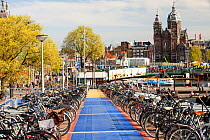 Bikes in bike racks in Amsterdam, Netherlands. A huge percentage of the population cycle in this flat, low lying country. April 2013.