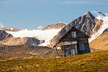 Old house at Recherchefjorden, Van Keulenfjorden, Spitsbergen, Svalbard. It is gradually sliding down slope due to solifluction and permafrost melt. Norway, July 2013.