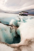 Twenty ton ice explorer truck  next to a Moulin, or sink hole for meltwater. Iceland, September 2010.