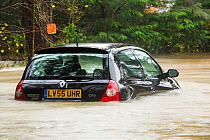 Abandoned car in flood waters in Ambleside, after the River Rothay burst its banks in the Lake District on Saturday 5th December 2015, during torrential rain from storm Desmond. England, UK, December...