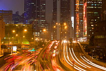 Office blocks lit up at night and cars in Hong Kong, China. February 2010.