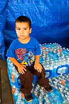 Young boy with bottled water supplied from water charity in Porterville to people who have had no running water for five months. California, USA, October 2014.