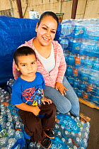 Mother and child with bottled water supplied from water charity in Porterville to people who have had no running water for five months. California, USA, October 2014.