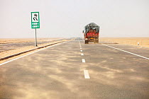 Dust storm blowing sand across highway in Inner Mongolia during severe drought, China, March 2009.