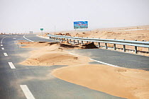 Sand dunes spreading across highway during severe drought,  Inner Mongolia, China. March 2009.
