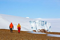 Tourists on beach with Mountain peaks on Joinville Island, Antarctic Peninsula.