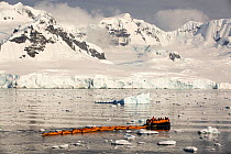 Members of an expedition cruise to Antarctica in a Zodiac with sea kayaks, Fournier Bay, Gerlache Strait, Antarctic Peninsula.