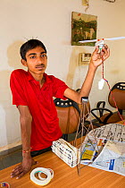 Student making a fan powered by solar electricity. Muni Seva Ashram in Goraj, near Vadodara, India. December 2013.
