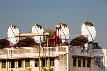 Solar panels that focus the suns rays on heat exchangers to boil oil, which is then sent down to the kitchens below to heat the cookers. Muni Seva Ashram,  Goraj, near Vadodara, India, December 2013.