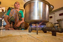 Staff in the old folks home kitchen cooking using biogas generated in the grounds. Muni Seva Ashram, Goraj,  Vadodara, India, December 2013.