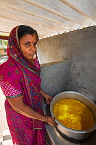 Woman with solar cooker used to cook food for the school students at Muni Seva Ashram, Goraj, near Vadodara, India. December.