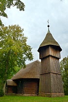 Old wooden church and belfry with thatched roofs from Masuria, now within the Ethnographic Park, Olsztynek, Poland, September 2017.
