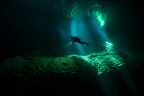 Diver underwater in the Abismo Anhumas or Anhumas Abyss. This is a 80 metre deep lake, at the bottom of a 72 metre deep cave. Bonito area, Serra da Bodoquena (Bodoquena Mountain Range), Mato Grosso d...