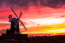 Windmill at Cley Next the Sea with Blakeney church in the background at sunset. North Norfolk, UK, February 2015