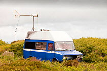 Camper van with a wind turbine used to power a computer and other electrical equipment near Zennor, Cornwall, UK. June 2010
