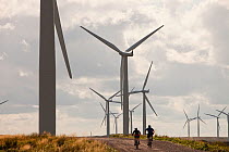 Mountain bikers at Black Law windfarm near Carluke in Scotland, UK. When it was constructed it was the largest wind farm in the UK with 54 turbines with a capacity of 97 Megawatts, enough to power 70,...