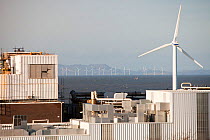 The Kodak factory in Workington Cumbria, with a wind turbine helping to power the plant, and the Robin Rigg offshore wind farm in the background. England, UK. January 2012
