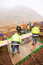 Cement being pumped into the foundations in initial groundworks for 3 wind turbines, Kirkstone Pass, Lake District, England, UK.  February 2012.