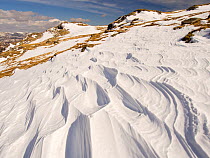 Snow shaped and scoured by a strong wind when it fell, above Wrynose Pass in the Lake District, Cumbria, UK. April 2013