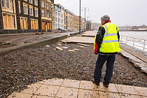 Paving slabs which have been ripped up and tossed 30 feet across the street after severe storm, Aberystwyth, Wales, UK. January 2014
