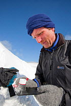 Member of the Scottish Avalanche Information Service looks at snow crystals to help assess avalanche risk on  Cairngorm in the Cairngorm National Park, Scotland, UK. March 2009