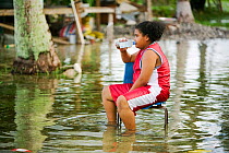 Child sitting on chair in floodwaters on Funafuti,Tuvalu. These low lying islands are very susceptible to sea level rise, March 2007