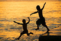 Tuvaluan children leaping into the sea on Funafuti Atoll, Tuvalu. March 2007