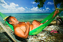 Man relaxing in hammock on a beach on Funafuti Atoll, Tuvalu. March 2007. These islands are very low lying and sucseptable to sea level rise.