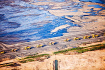 Massive dump trucks with  load with tar sand in a mine north of Fort McMurray, Alberta, Canada. August 2012