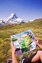 Person holding a map, with the Matterhorn in the background, above Zermatt, Switzerland. June 2004