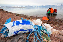 Tourists collecting plastic rubbish on a remote beach in Northern Svalbard, only about 600 miles from the North Pole. The plastic has been washed ashore by ocean currents. July 2013