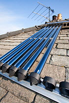 Solar water heating panel being fitted to a house roof in Ambleside, Cumbria, UK. April 2009