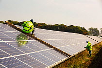 Technicians work on Wymeswold Solar Farm the largest solar farm in the UK at 34 MWp, based on an old disused second world war airfield, Leicestershire, UK. It contains 130,000 panels and covers 150 ac...