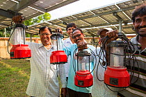 Man with new solar lanterns from  WWF project to supply electricity to a remote island in the Sunderbans, Ganges Delta, India. December 2013
