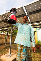 Man with new solar lanterns from  WWF project to supply electricity to a remote island in the Sunderbans, Ganges Delta, India. December 2013