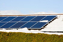 Solar panels on a house roof in Ambleside in the snow, Lake District, UK. February 2012