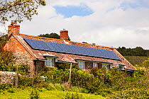 Solar panels on an old house on the Dorset coast near Charmouth, UK. June 2012