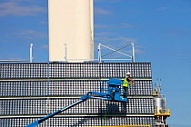 A man cleans high concentration photo voltaic panels being trialled by the research and development arm of Abengoa Solar, at their Solucar solar complex in Sanlucar la Mayor, Spain. Abengoa are invest...